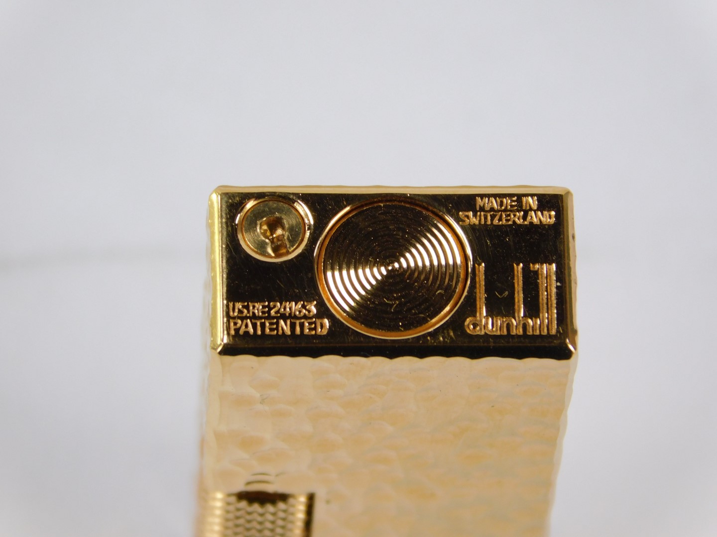 A Dunhill pocket lighter, in gold coloured bark effect case, number 24163, 6.5cm high, with outer su - Image 2 of 2