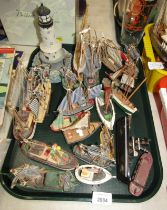 Various model treen fishing boats, together with a model of a lighthouse.