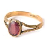 A 9ct gold amethyst dress ring, with the oval amethyst in rub over setting with V splayed shoulders,