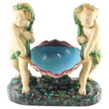 A Minton Majolica centrepiece, modelled in the form of two putti holding a clam shell, on a rectangu