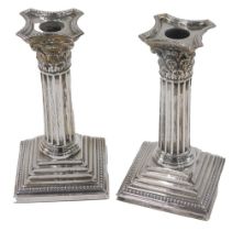 A pair of George V silver candlesticks, each of tapered and columned form, on weighted bases, Sheffi