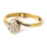 An 18ct gold and platinum twist ring, the floral cluster set with tiny diamonds, with white metal tw