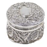 An Edward VII silver dressing table jar, with hammered floral decoration, with daisies and tulips, B