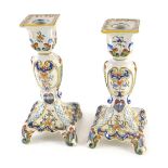 A pair of Fourmaintraux Freres Desvres candlesticks, each decorated with foliate scrolls, flowers,