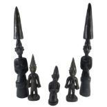 A pair of African ebonised wood tribal figures, each with a tusk shaped top and three further small