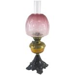 A Victorian brass iron oil lamp, with etched pink tinted Art Nouveau shade, the base 31cm high.
