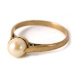 A cultured pearl dress ring, the single pearl in tension setting on a yellow metal band, stamped 9ct