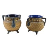 A near pair of Royal Doulton tygs or three handled cauldron, each with incised bands in gilt, within