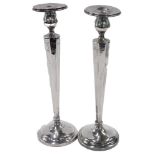 A pair of George V candlesticks, each on a fluted octagonal embossed stem, on a weighted base, Birmi
