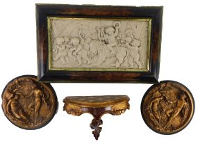 A Continental resin plaque, decorated with putti and a lion, a pair of similar plaques and a small V