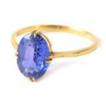 An 18ct gold and tanzanite dress ring, the oval tanzanite in four double claw setting on a raised sh