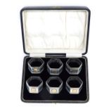 A cased set of six George V silver napkin rings, hexagonal form with engraved decoration, 4.5oz.