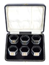 A cased set of six George V silver napkin rings, hexagonal form with engraved decoration, 4.5oz.