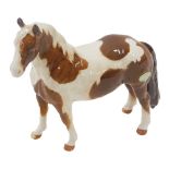 A Beswick Skewbald Pinto pony, glazed finish with green label.