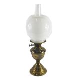 A brass oil lamp, with opaque white globe shade, and an hourglass shaped moulded base, 50cm high.