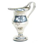 An Edward VII silver pedestal cream jug, Chester 1909, weighted base.