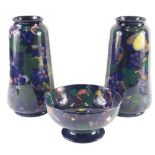 A pair of Royal Stanley Jacobean ware pottery vases, each decorated with fruit and leaves, on a