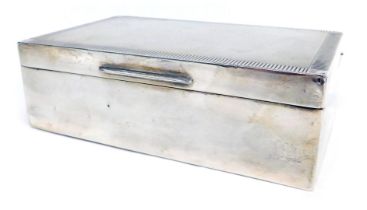 An Elizabeth II silver cigarette box, engine engraved decoration, Birmingham 1954, 12cm wide.