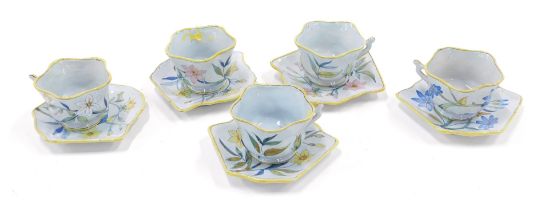 A set of five Porquier Beau Faience botanical cups and saucers, each with a shaped edge, handwritten