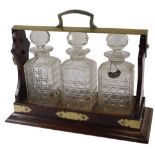 A mahogany and silver plated tantalus, with square sectioned decanters and stoppers, etc., 39cm wide