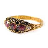 A 15ct gold ruby gypsy ring, set with two oval rubies and a square cut central ruby, with tiny emera