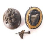 Two carved jet oval brooches, comprising a oval example with yellow metal buckle outer border and ce