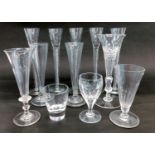 A set of five glasses, each with an air twist stem, and other glasses.