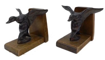 A pair of Art Deco oak bookends, each mounted with a bronze duck in landing position, unmarked, 13.5