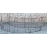 A pair of circular wrought iron railings or tree guard sections, 242cm wide.