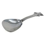 An Arts and Crafts hammered silver caddy spoon, with plain arm, with pierced sides and tapering end,
