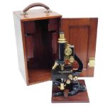 A late 19th/early 20thC brass and ebonised microscope, one lens stamped Watson of London, in a fitte