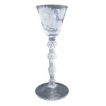 A wine glass, the bell shaped bowl engraved with flower and leaves, on a quadruple air twist stem, w