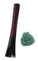 A small green Oriental hardstone pendant carved as a putto, and a Bakelite cheroot holder, in fitted