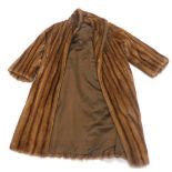A brown full length fur coat, label for Bradley's Furriers.