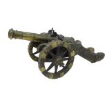 A brass miniature replica cannon, decorated with a crown, etc., 29cm long overall.