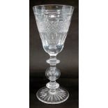 A large wine glass, the bell shaped bowl engraved with hobnail cutting and faceted, on a knopped col