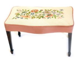 A mahogany stool in George II style, the serpentine fronted padded top embroidered with flowers, in