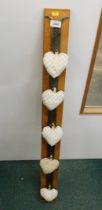 A hardwood hanging rack, with material heart cushions.