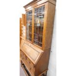 An oak bureau bookcase, with stained glass panelled doors, on barley twist column supports.