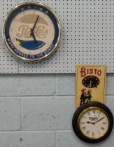 A Pepsi wall clock, Carlsberg wall clock and a Bisto wall clock.