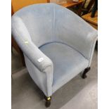 A blue upholstered tub chair, on mahogany legs.