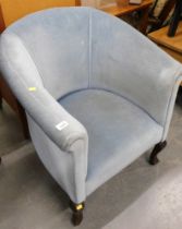 A blue upholstered tub chair, on mahogany legs.