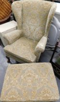 A Parker Knoll green floral seated armchair and matching footstool.