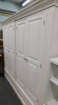 A white painted four door wardrobe with two drawers below.