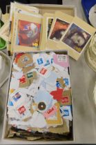 A quantity of coloured postcards and loose postally worn stamps. (1 box)