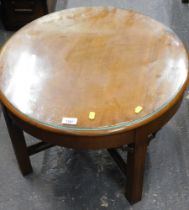 A walnut circular side table, with X frame base and arched corners.