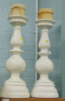 A pair of white plastic candle stands, with candles.