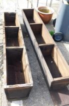 Two wooden three sectional feeding troughs.