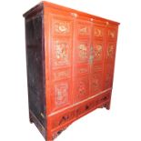 A Chinese red lacquered marriage cabinet, the pediment over four doors, enclosing shelves and four d