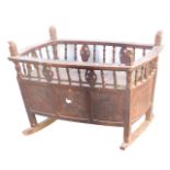 A Chinese hardwood child's cradle, the side panels carved with flowers, 70cm high, 92cm wide, 58cm d